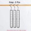 Three grey folding hangers hanging from a wooden rod
