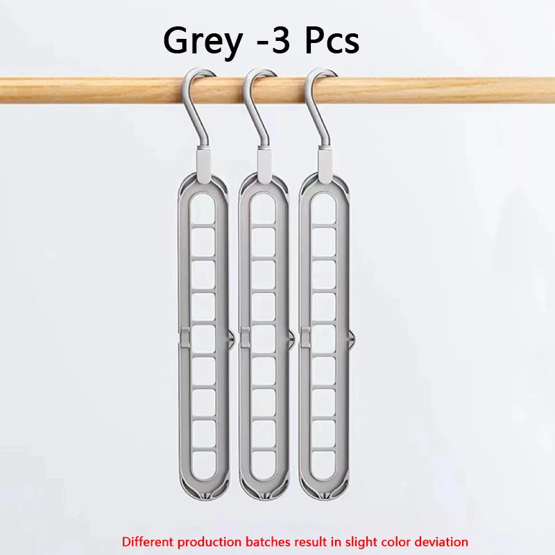 Three grey folding hangers hanging from a wooden rod