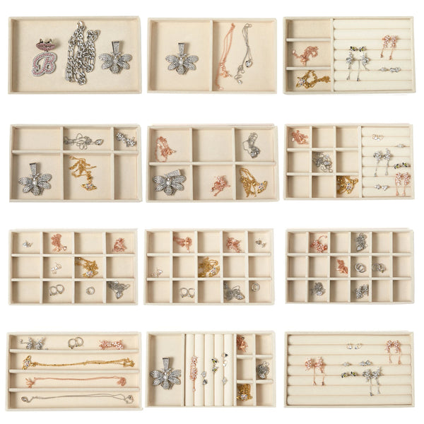 A collection of velvet jewelry organizer trays with various compartments and decorative dividers.