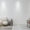 A modern interior featuring a white diamond pattern wall panel and a light sofa with neutral cushions.