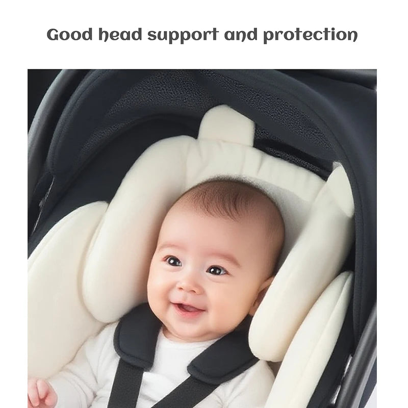 A baby is seated in a white and black stroller seat cushion designed for good head support and protection.