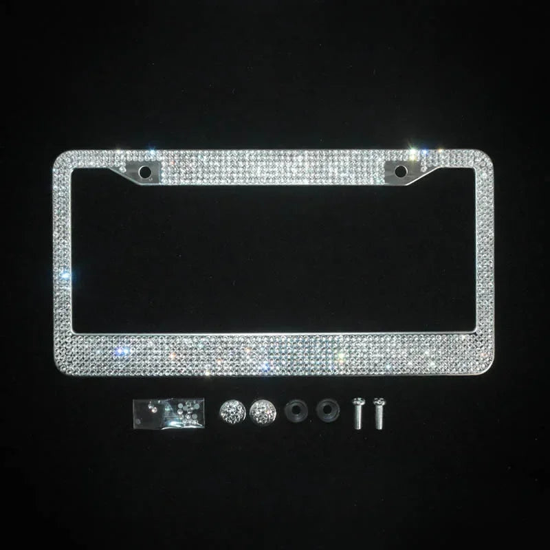 A rectangular crystal rhinestone license plate frame with mounting tabs and small hardware components.