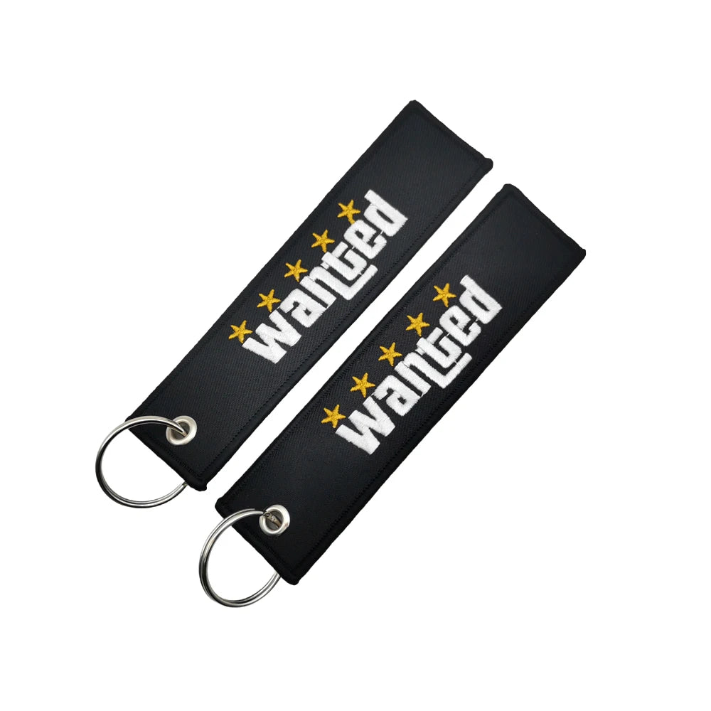 Black nylon keychain with embroidered wanted text and steel spring clip