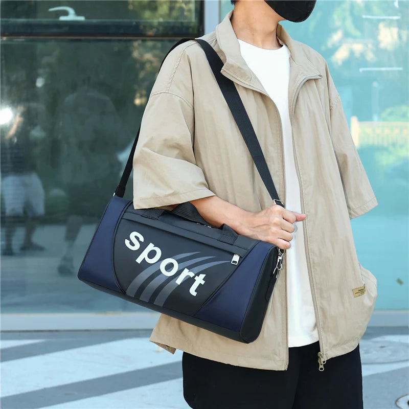 A person wearing a beige jacket is carrying a black and gray duffel bag.