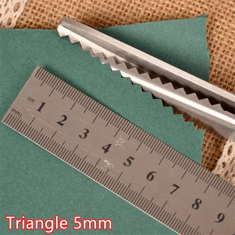 A pair of metal triangle-shaped pinking shears is shown next to a ruler measuring 9 centimeters.