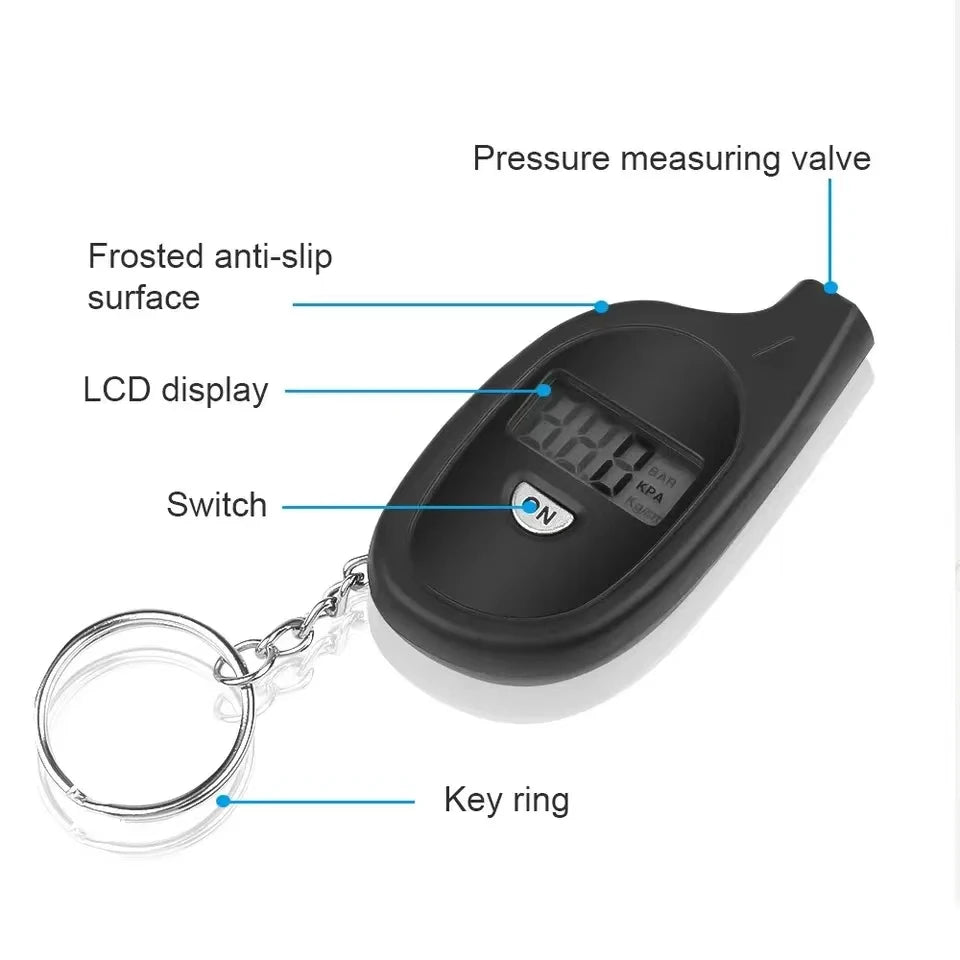 A black digital tire pressure gauge with a measuring valve, LCD display, switch, and key ring attached.