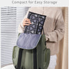 A person is holding a compact, olive green foldable waterproof baby changing pad bag.