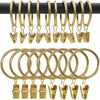 Anillos y clips metálicos de oro para cortinas, colgados en una barra negra