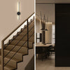 Modern interior featuring a staircase with vertical LED wall sconces and a dark vertical panel.