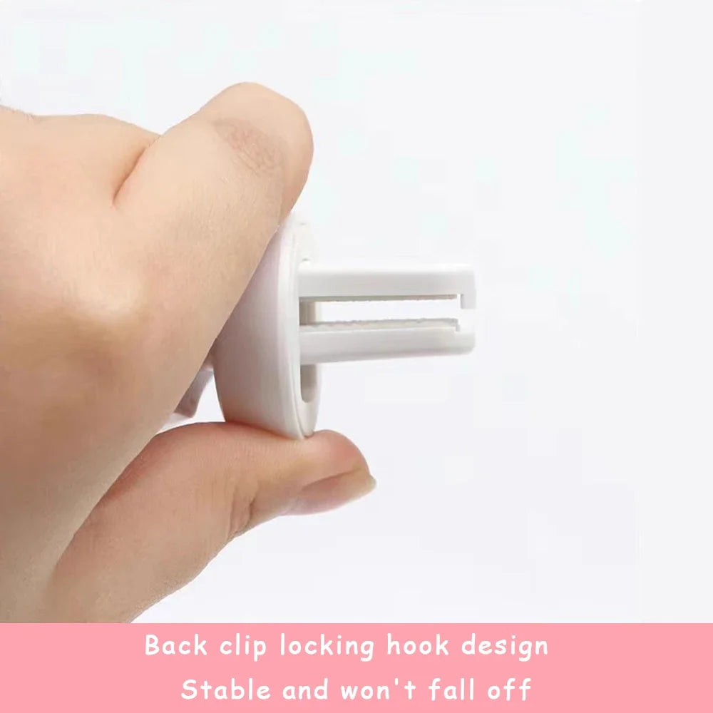 A hand is holding a white gravity car phone mount with a back clip locking hook design.