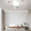 Modern white ceiling fan with multiple light heads and a large circular diffuser in a bedroom setting