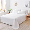 Weiße Premium-Einzelbettdecke ausgebreitet auf einem Bett mit weißen Kissen und Holzknotenfußschrank.