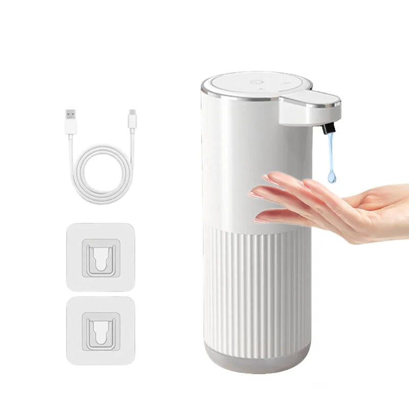 A white touchless automatic soap dispenser with a pump, along with its charging cable and replacement parts.