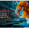 Mechaniker in orangefarbener Hemd arbeitet an einem Motor und nutzt eine Rauchmaschine zur Diagnose und Reparatur.