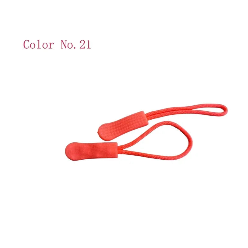 A close-up view of a bright coral red plastic zipper pull.