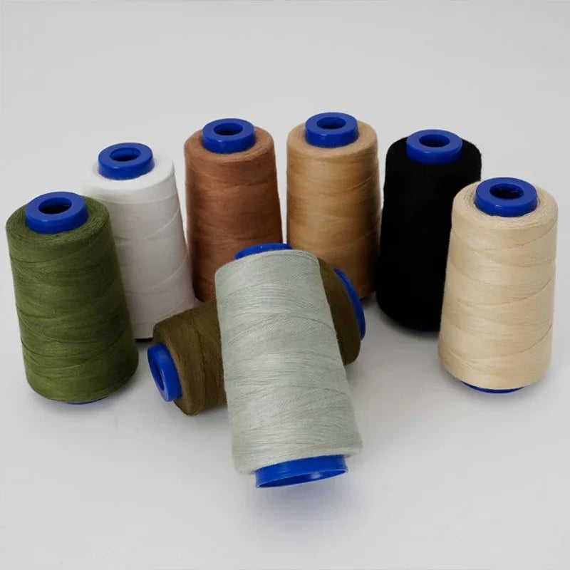 A collection of spools of heavy-duty polyester thread in various colors including green, brown, beige, and black.