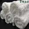 A stack of white, fluffy cotton muslin baby washcloths rolled into balls.