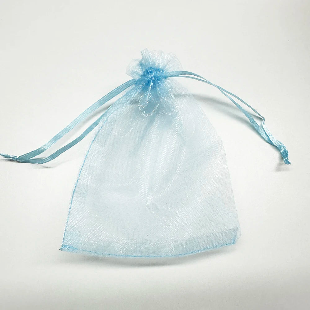 A sheer light blue organza drawstring bag tied with a matching ribbon.