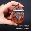A hand holds a small wooden kalimba thumb piano with metal tines, designed to be convenient to carry.