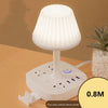 A white multifunctional desk lamp with a shade, USB charging hub, and phone holder, shown on a wooden surface.