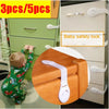 A set of adhesive baby safety locks for drawers and cupboards, shown on a cabinet and a wooden block.