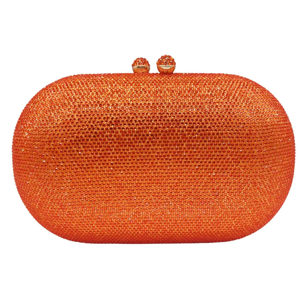 Pochette orange ronde texturée avec petits strass et bandoulière en chaîne dorée.