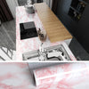 Pink marble wallpaper featuring white veining used as a surface for a kitchen countertop and furniture.