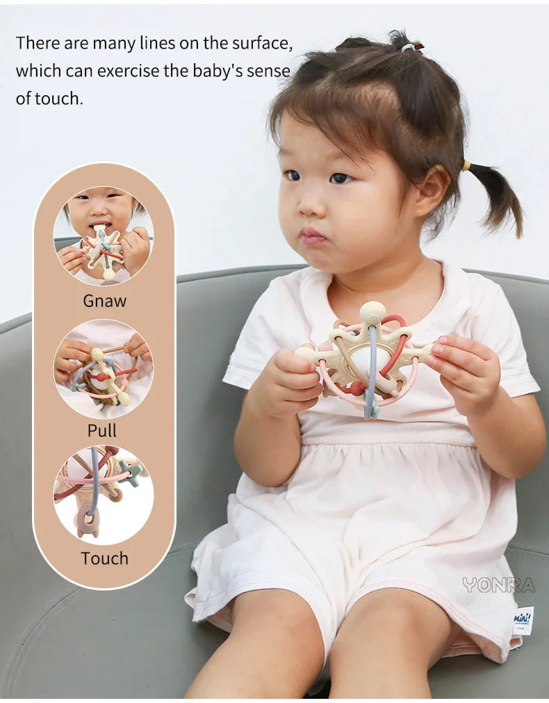 A baby is shown interacting with a silicone sensory rattle ball, demonstrating gnaw, pull, and touch sensations.