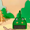 A green cartoon broom and dustpan set with a cute face is shown on a light background.