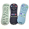 Three silicone baby teethers in green, black, and light blue with various shapes and buttons