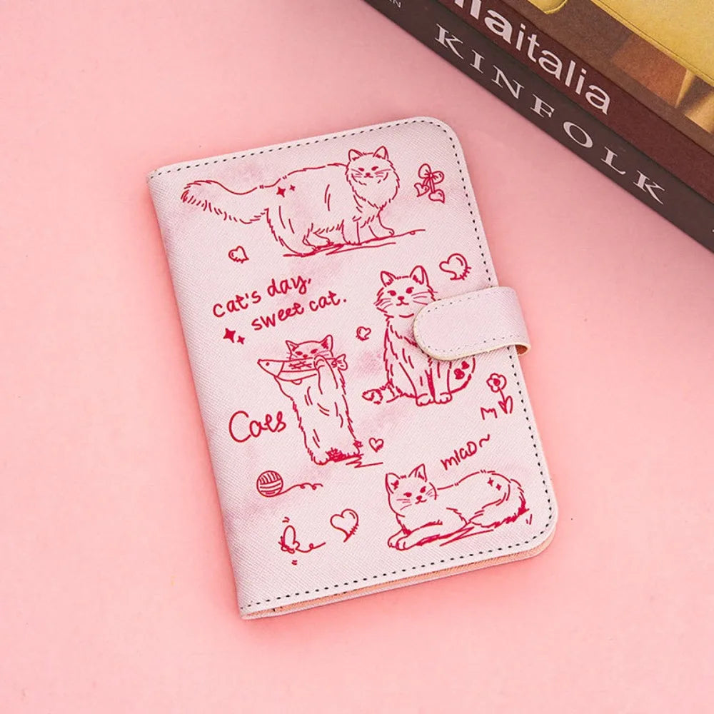 A pink pu leather passport holder featuring hand-drawn cartoon cats and text.