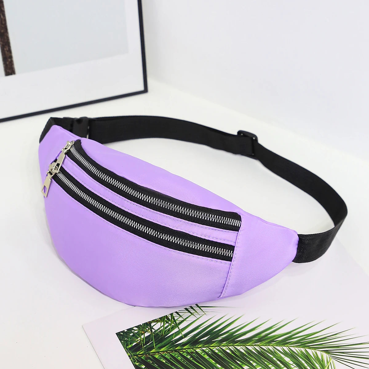 A purple nylon waist pack with a silver zipper is shown against a white background.