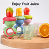 A set of colorful rotating silicone baby fruit feeders with dinosaur designs displayed on a wooden board.