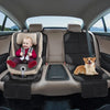 A dog rests on a seat in a car with a baby seated in a car seat protector.