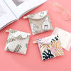 A collection of fabric cosmetic storage pouches featuring various floral and line art patterns on a pink background.