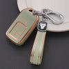 A light green TPU protective key case with a silver clip and leather strap is shown resting on a white surface.