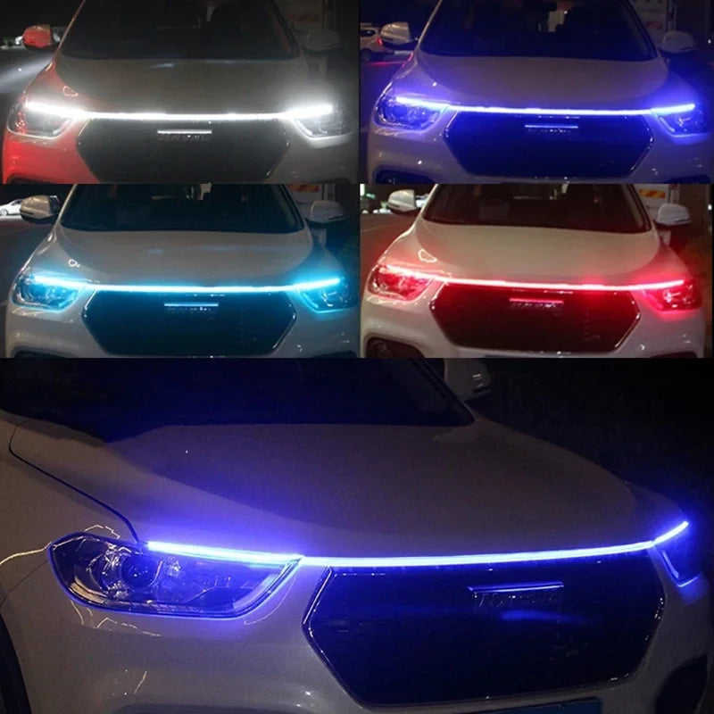 Close-up view of a white car's front grille with blue LED engine hood light strips activated.