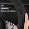 Close-up of a black steering wheel cover grip showing the NISSAN logo and texture.