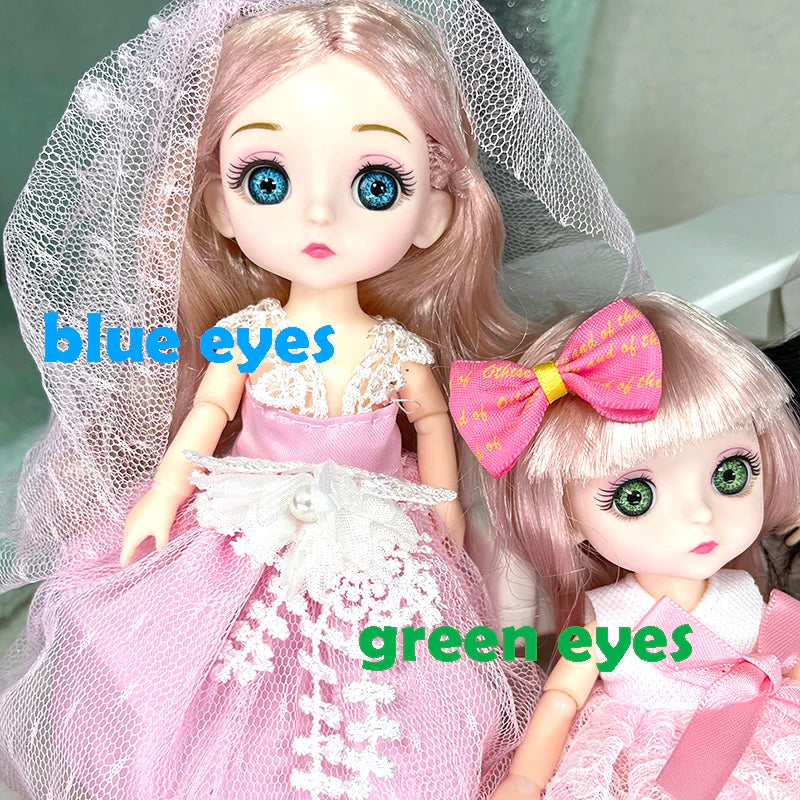 Two fashion dolls, one with blue eyes and another with green eyes, are shown wearing pink dresses.