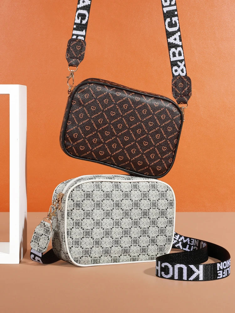 A brown patterned compact crossbody bag is displayed against an orange background, with a gray patterned bag and black straps