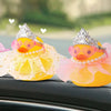 A collection of colorful rubber duck decorations with crowns, sunglasses, and pearl necklaces displayed on a car interior.