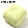 A small, light green, square-shaped portable soap holder with a rounded top and a visible seam.
