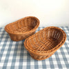 A brown handwoven wicker serving basket is displayed on a blue and white checkered tablecloth.
