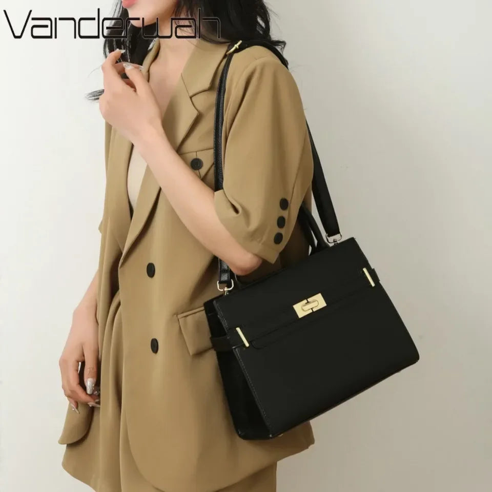 A woman wearing a beige blazer holds a black leather handbag with a gold clasp and a matching coin purse.