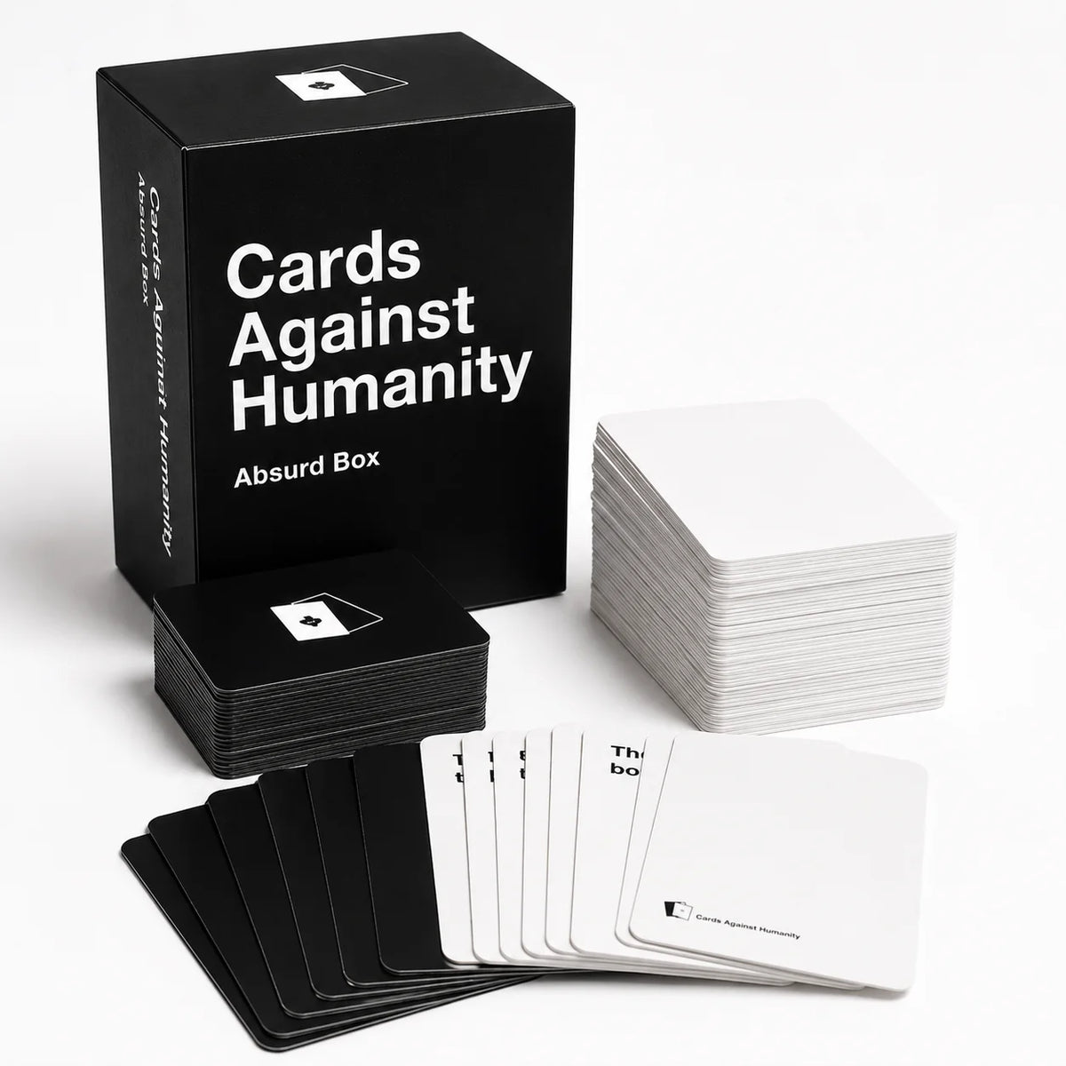 A black box of Cards Against Humanity with several stacks of white cards displayed on a white surface.