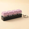 A black keychain featuring pink LED mechanical fidget toy keycaps.
