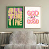 A set of two framed canvas prints featuring the text All God Is The Good Time in bright yellow and pink lettering on a green 