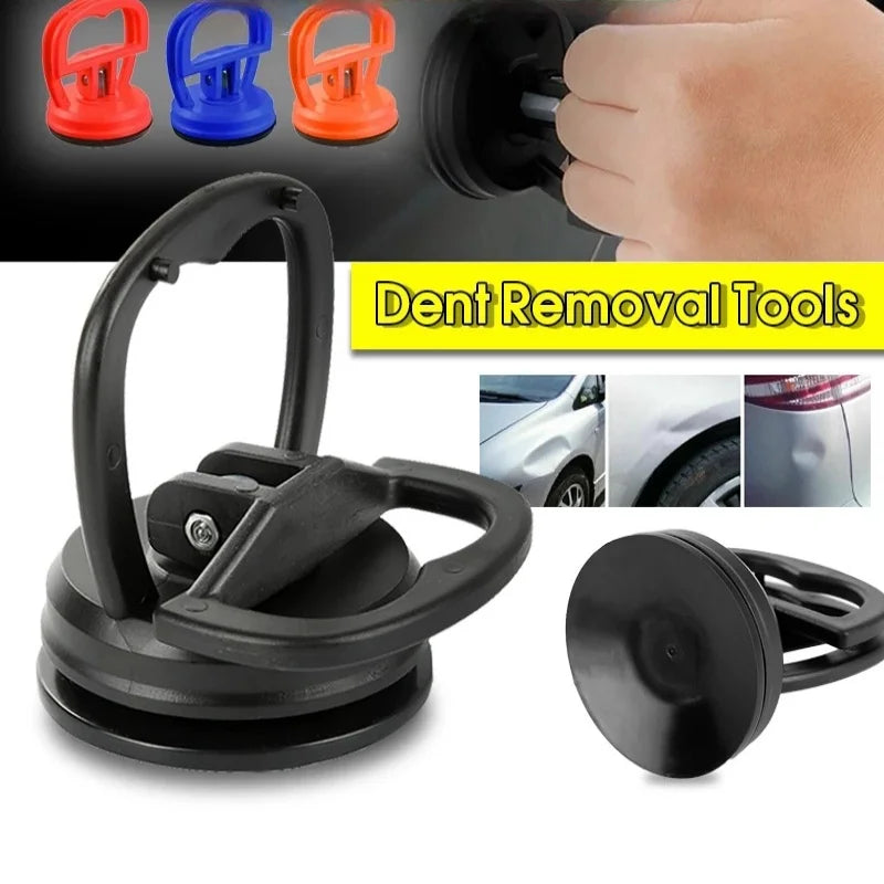 A set of black and colored dent removal tools including a puller and suction cups for automotive bodywork.