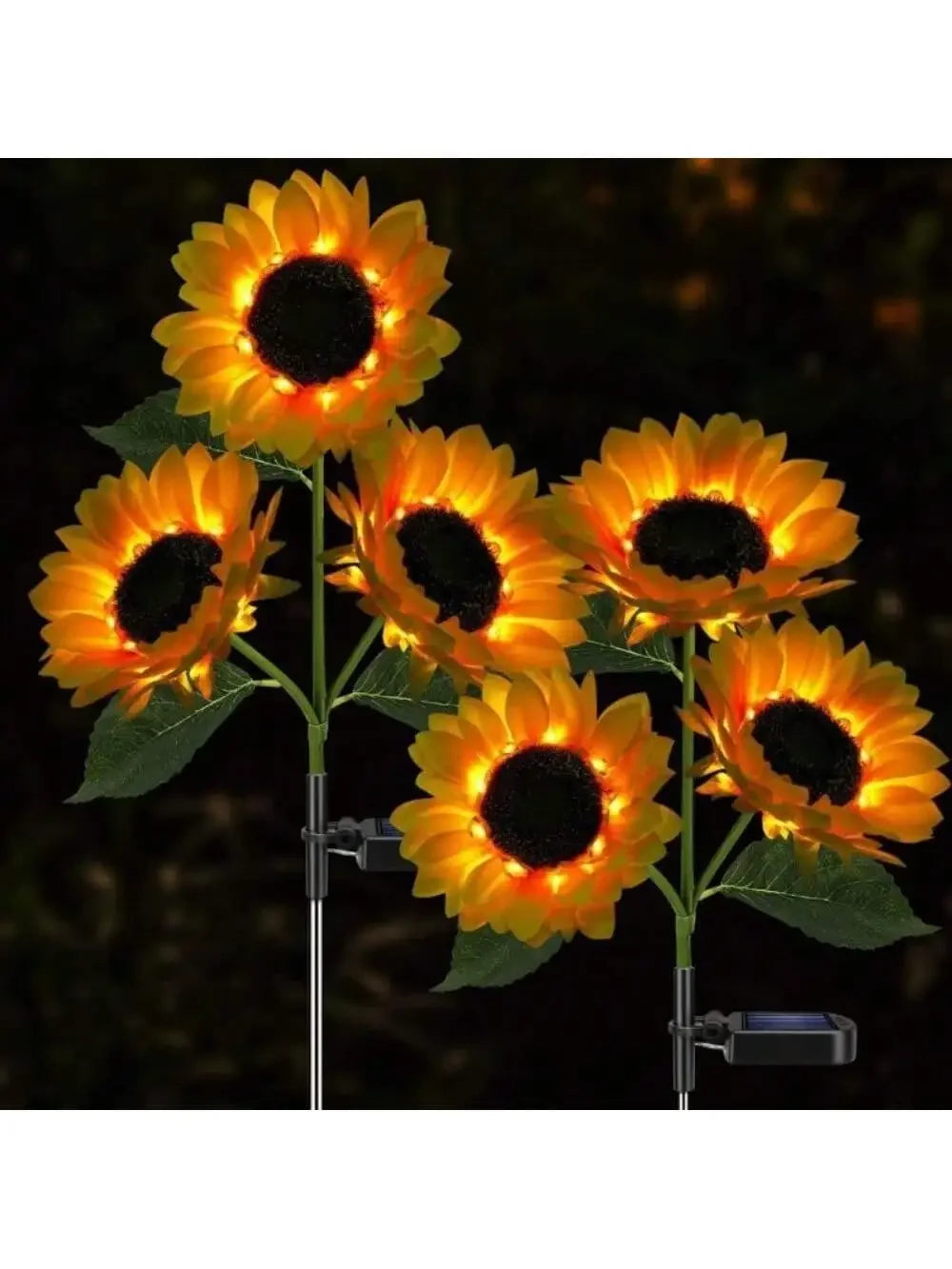 A close-up of a solar-powered LED sunflower garden light with bright orange petals and a dark center against a dark backgroun