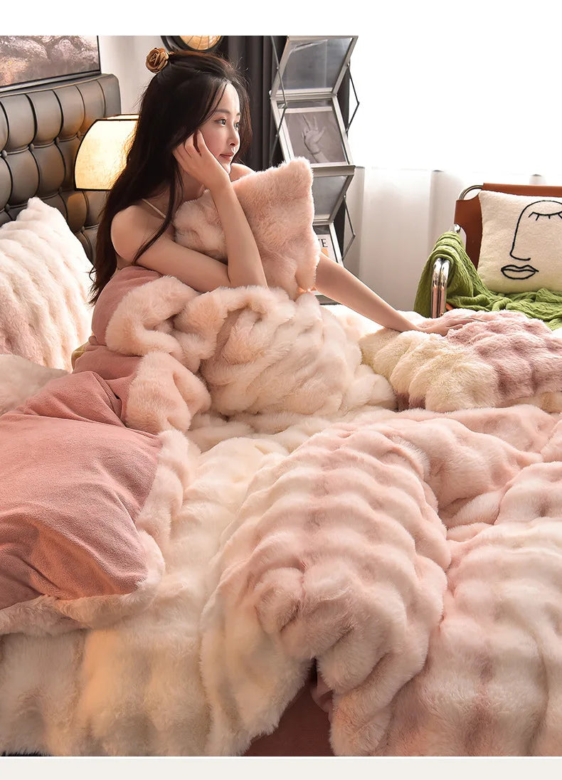 A close-up of a pink and cream ultra-soft plush bedding set featuring faux fur pillows and blankets.